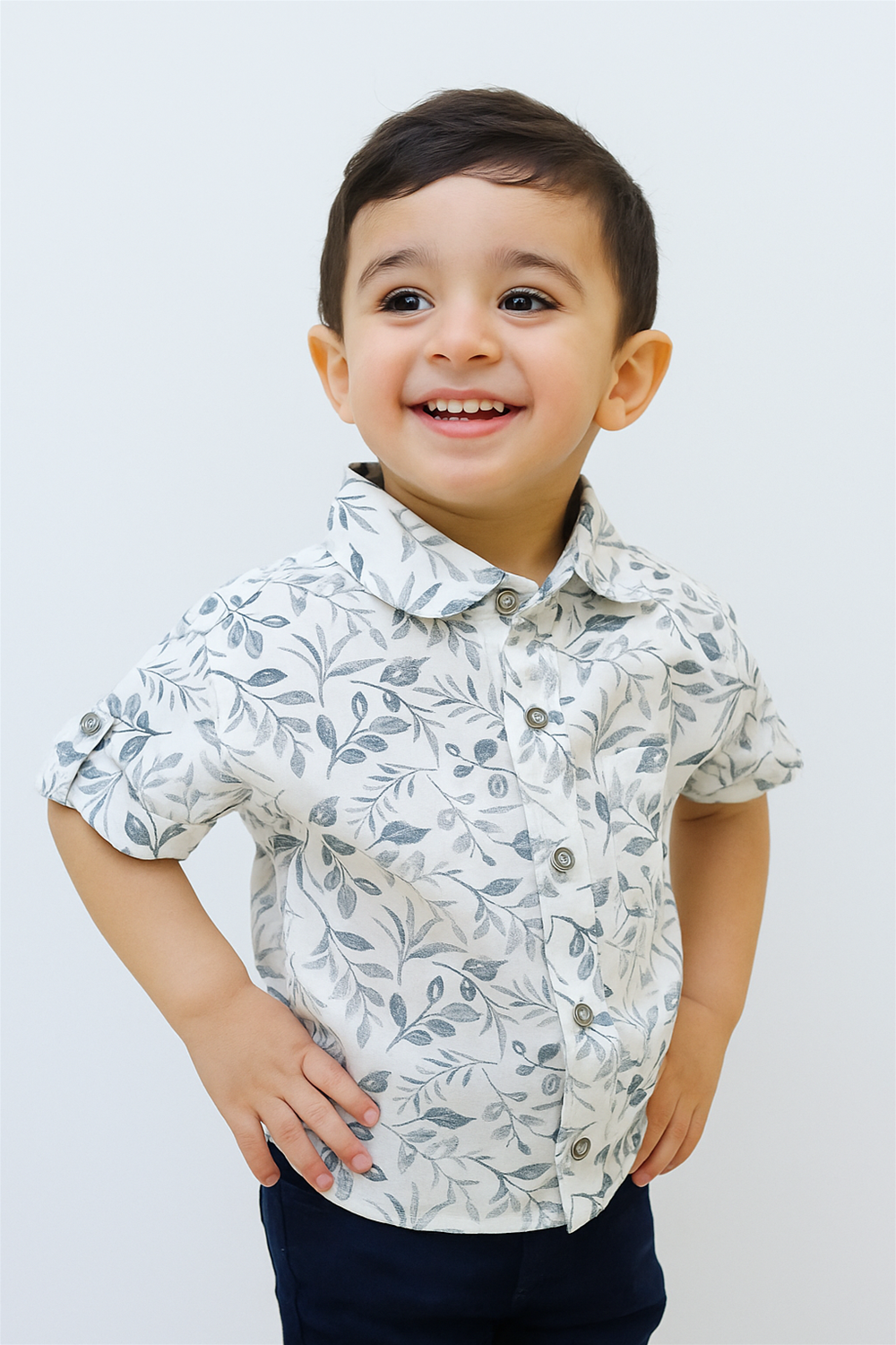 A cheerful toddler boy wearing a half-sleeve club collar shirt with an elegant leaf print design. Perfect for casual outings, the shirt combines soft fabric and smart style for everyday comfort.