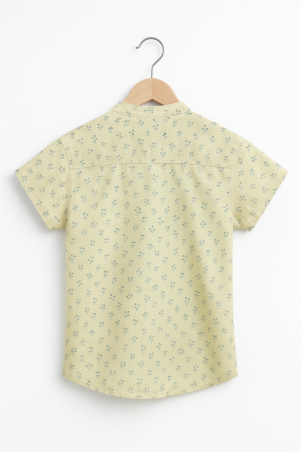Back view of a boys' half-sleeve Chinese collar shirt in light yellow with subtle blue floral prints. Displayed on a wooden hanger against a white background, showcasing its clean stitching and casual style.