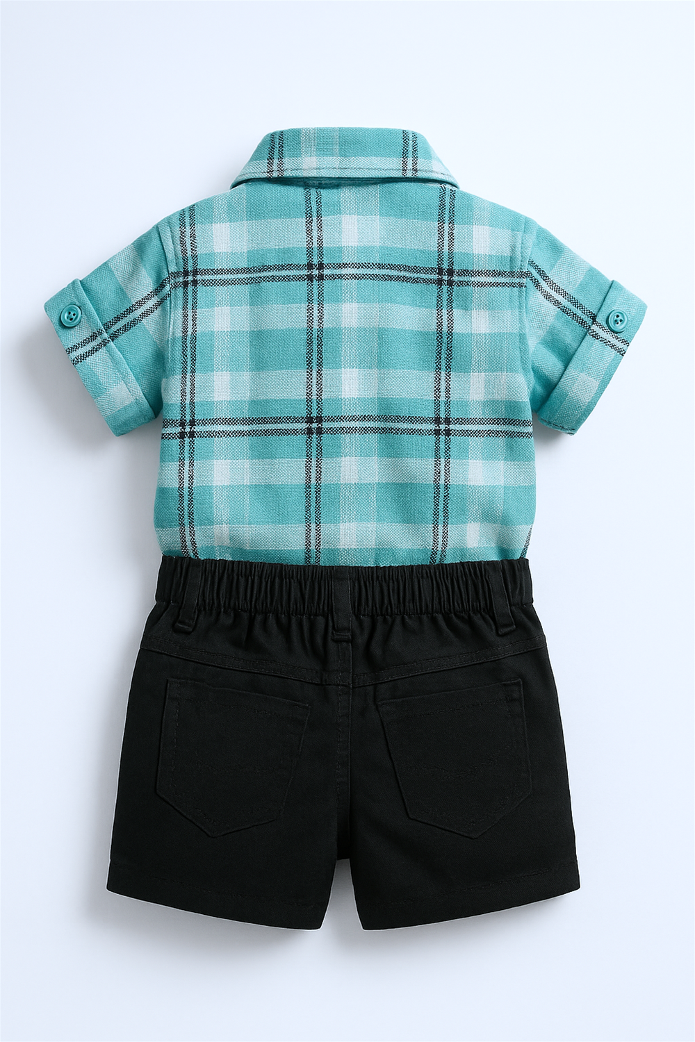 Back view of toddler outfit featuring teal plaid shirt with rolled sleeves and black shorts, displayed on plain white background.