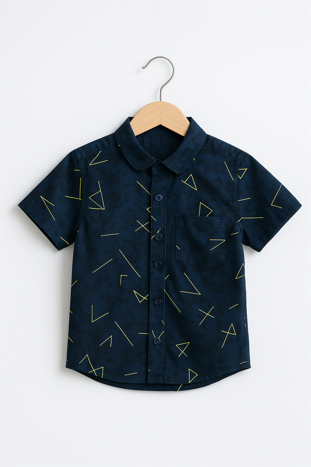 A navy blue half-sleeve club collar shirt for boys featuring a vibrant yellow geometric pattern. Displayed on a wooden hanger against a white background, ideal for showcasing product detailing.