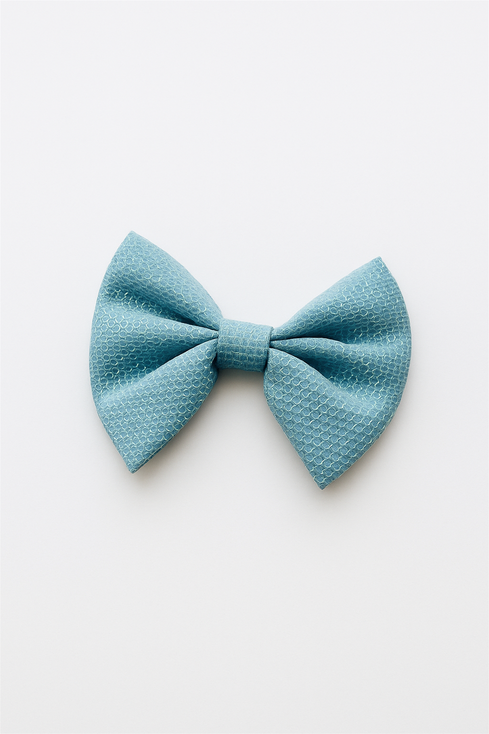 Stylish aqua blue bow hair clip with delicate patterned texture, displayed on a clean white background for product catalog photography.
