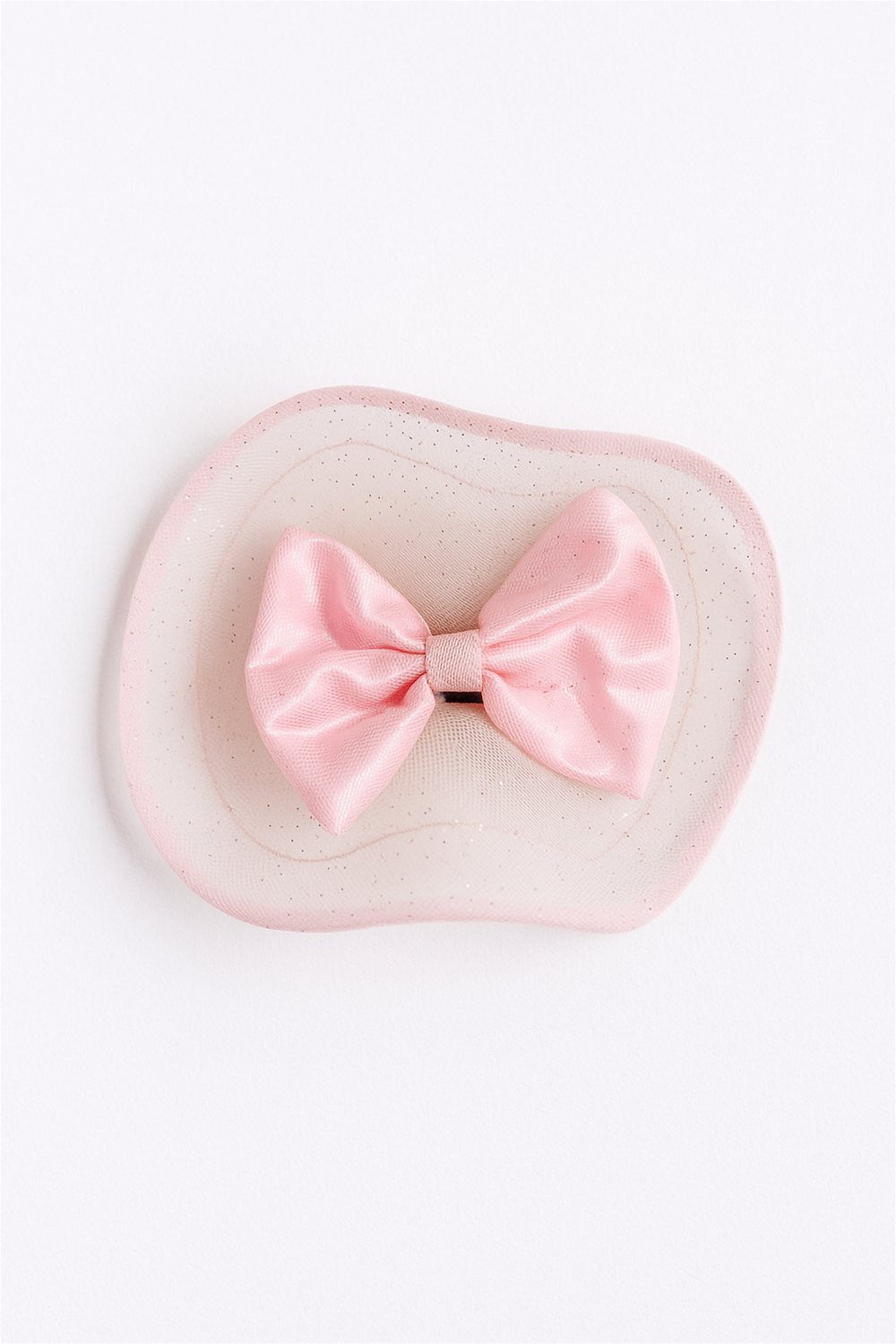 “Pink satin bow hair clip with sheer netting detail, photographed flat against clean white background for clarity.”