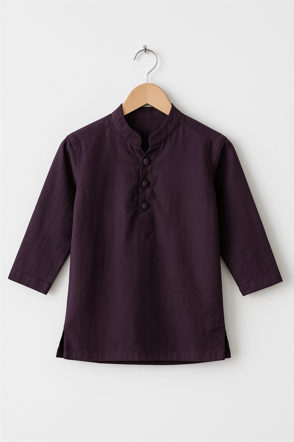 A deep purple boy’s kurta with a Chinese collar and matching fabric-covered buttons is displayed on a wooden hanger. The kurta features long sleeves and a simple, elegant design against a plain white background.