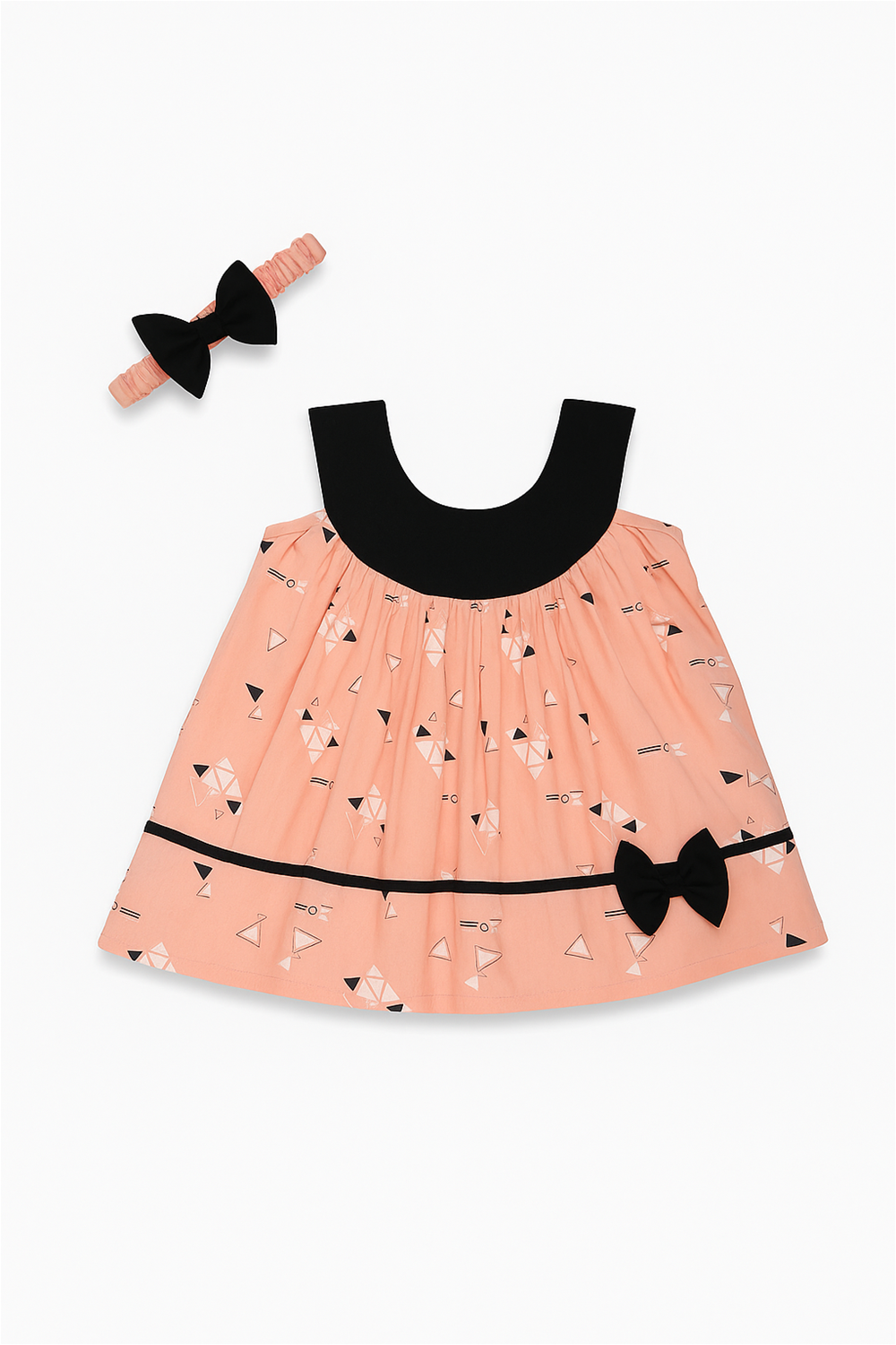 Peach frock with geometric prints, black neckline, decorative black bow at hemline with matching hanger.