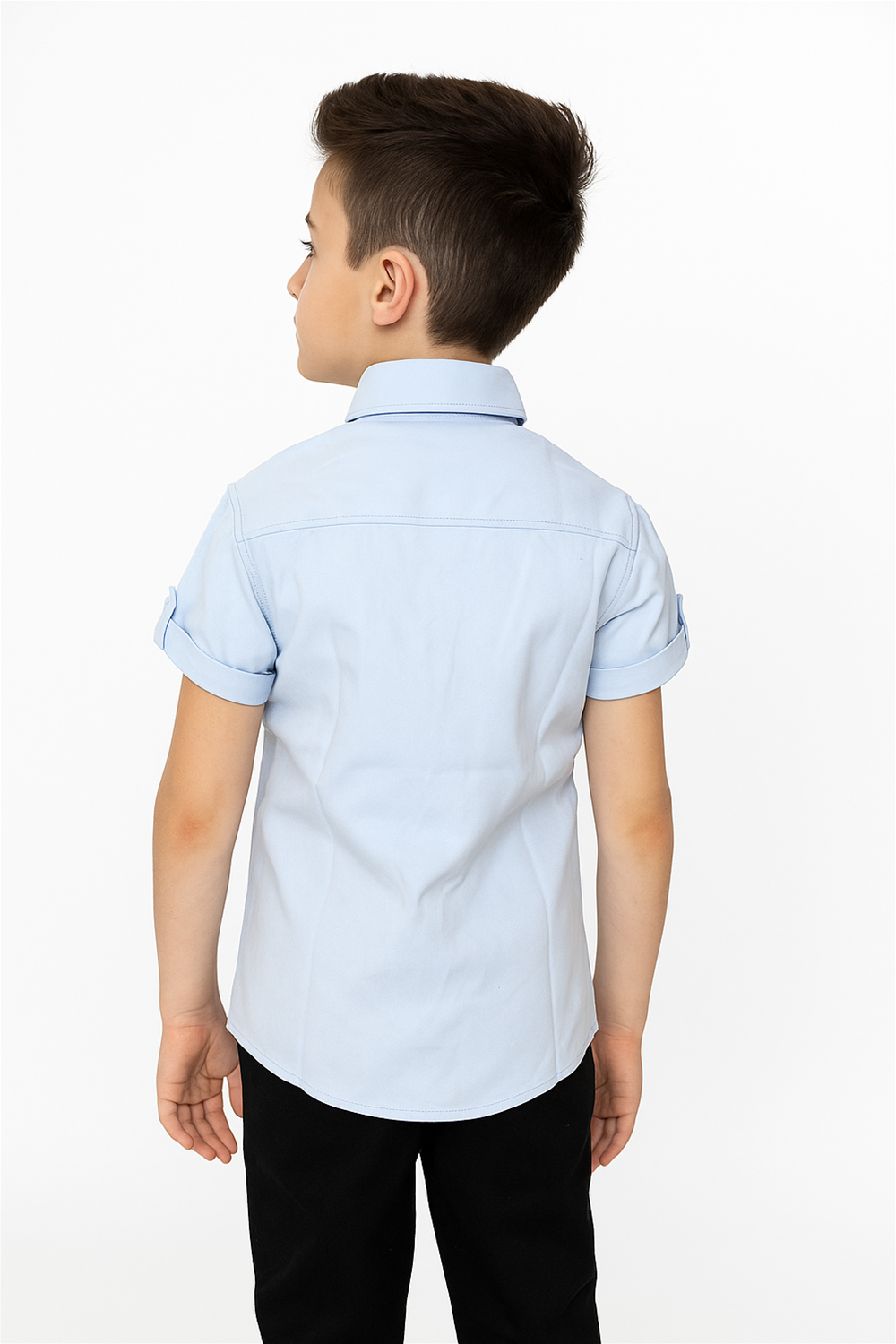 A young boy in a blue half-sleeve shirt with a normal collar, standing with his back facing the viewer.