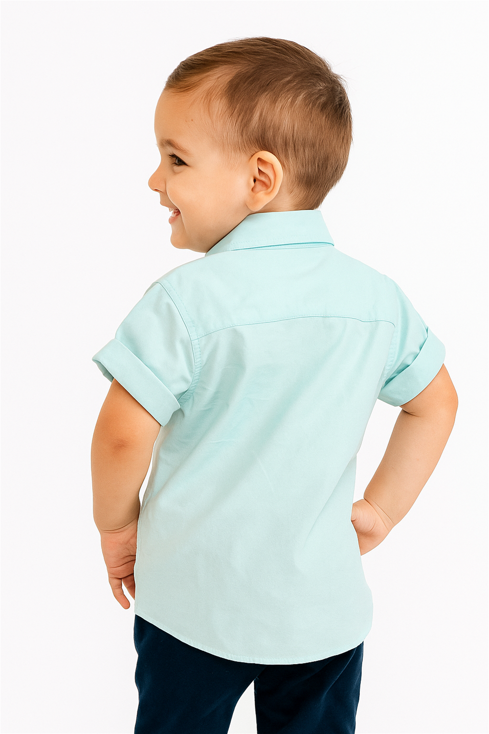 Back view of a young boy wearing a mint green half sleeves Chinese collar shirt with rolled cuffs. The shirt fits neatly and is paired with dark pants, creating a smart and cheerful look against a white background.