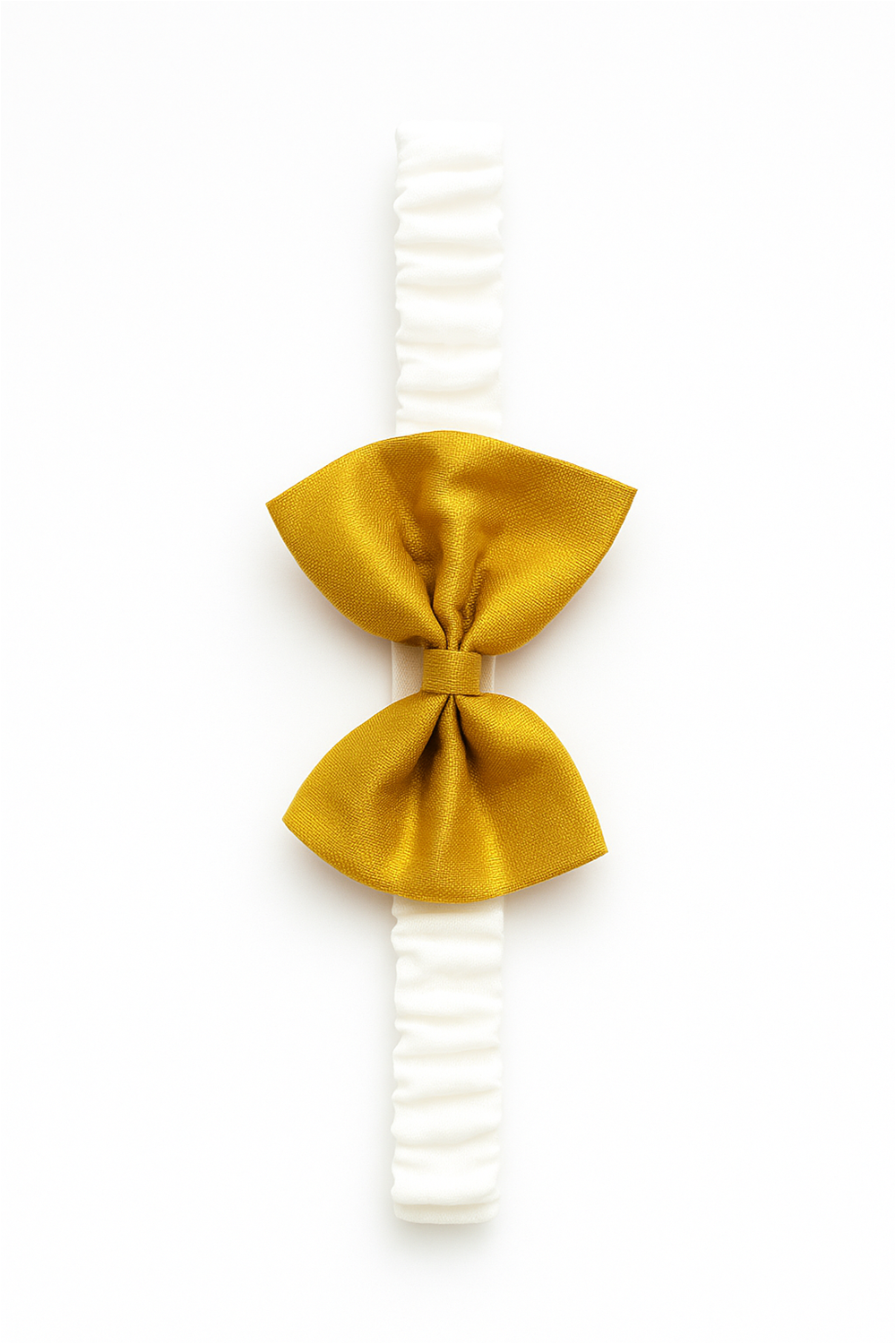 This is a close-up image of a baby headband featuring a golden bow attached to a soft white elastic band. The bow is neatly tied in the center, and the accessory is displayed on a plain white background, highlighting its elegant and festive design.