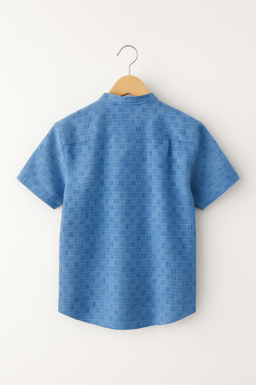 Back view of a boys' half-sleeve Chinese collar shirt in a blue checkered pattern. Displayed on a wooden hanger against a plain white background, ideal for showcasing garment detailing.