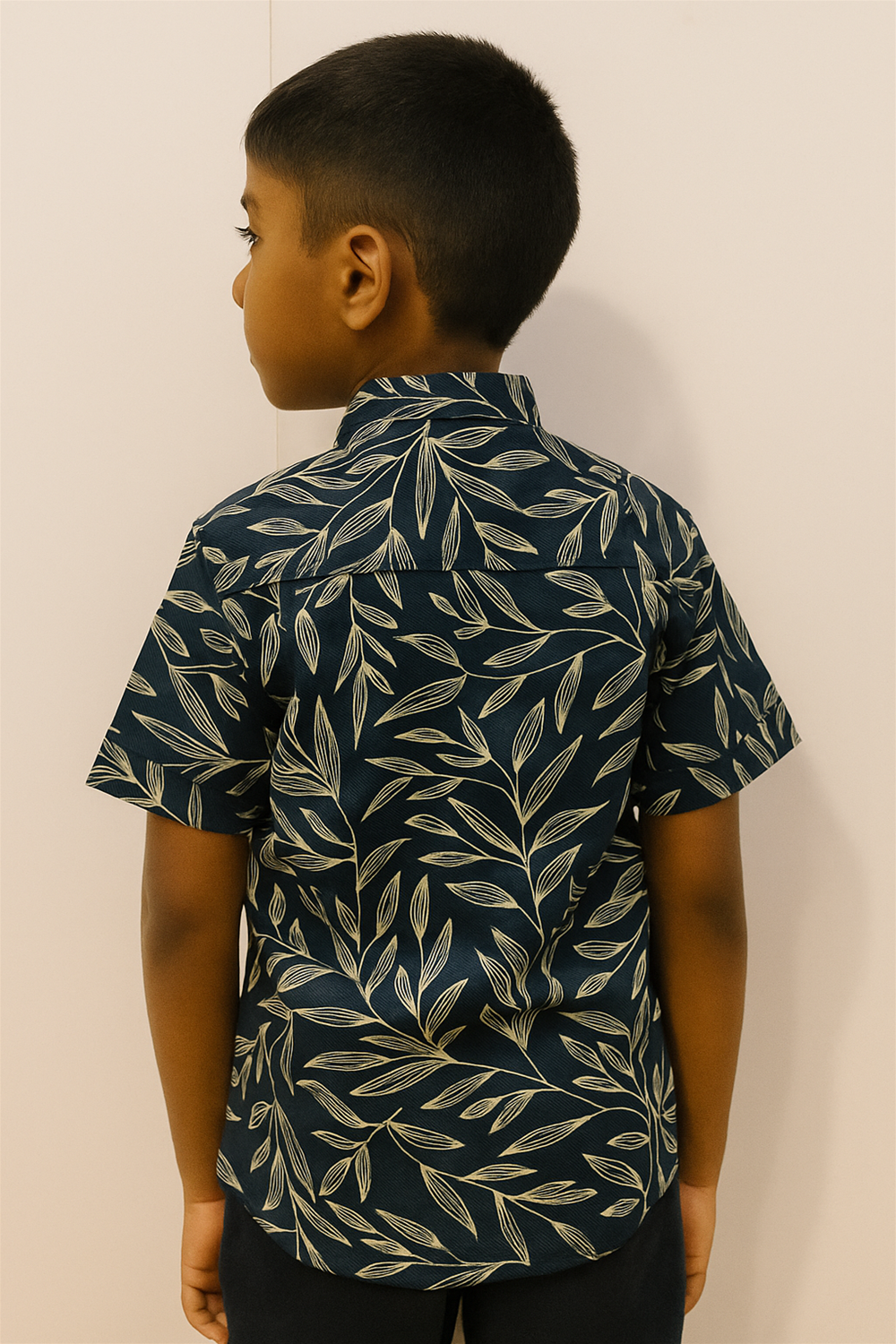 A young boy in a half-sleeve shirt with a Chinese collar, featuring a leaf pattern.