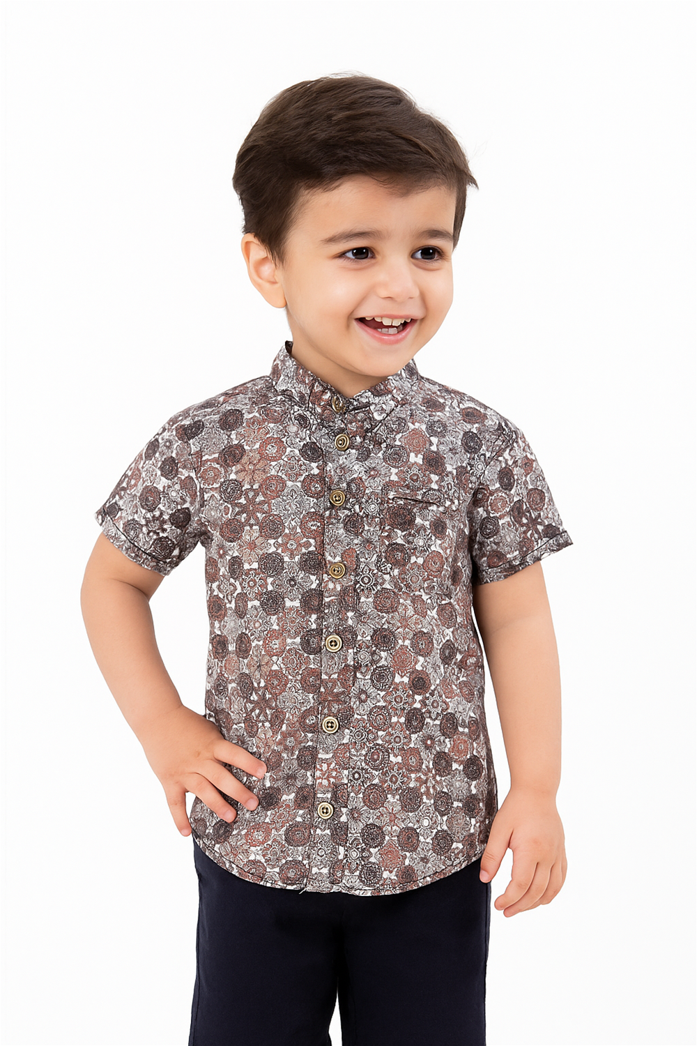 Front view of a toddler boy wearing a half-sleeve Chinese collar shirt with an intricate geometric print in earthy tones. The shirt features wooden buttons and is styled with navy corduroy cargo shorts and matching sneakers, perfect for a casual day at the playground.