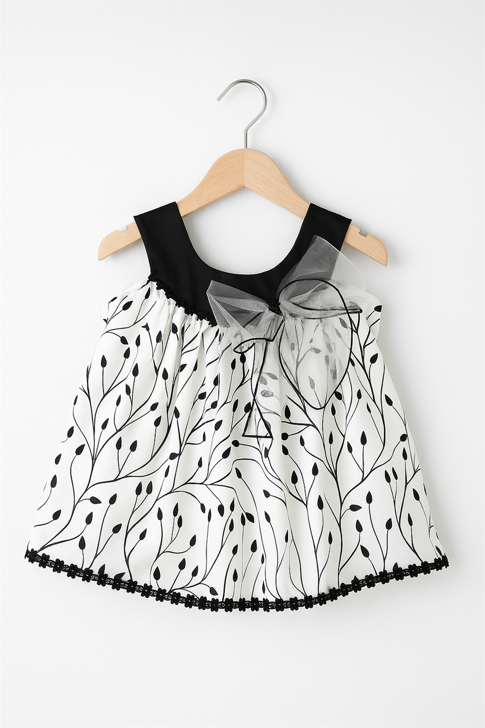 Elegant white and black dress adorned with a black bow, showcasing a chic design.