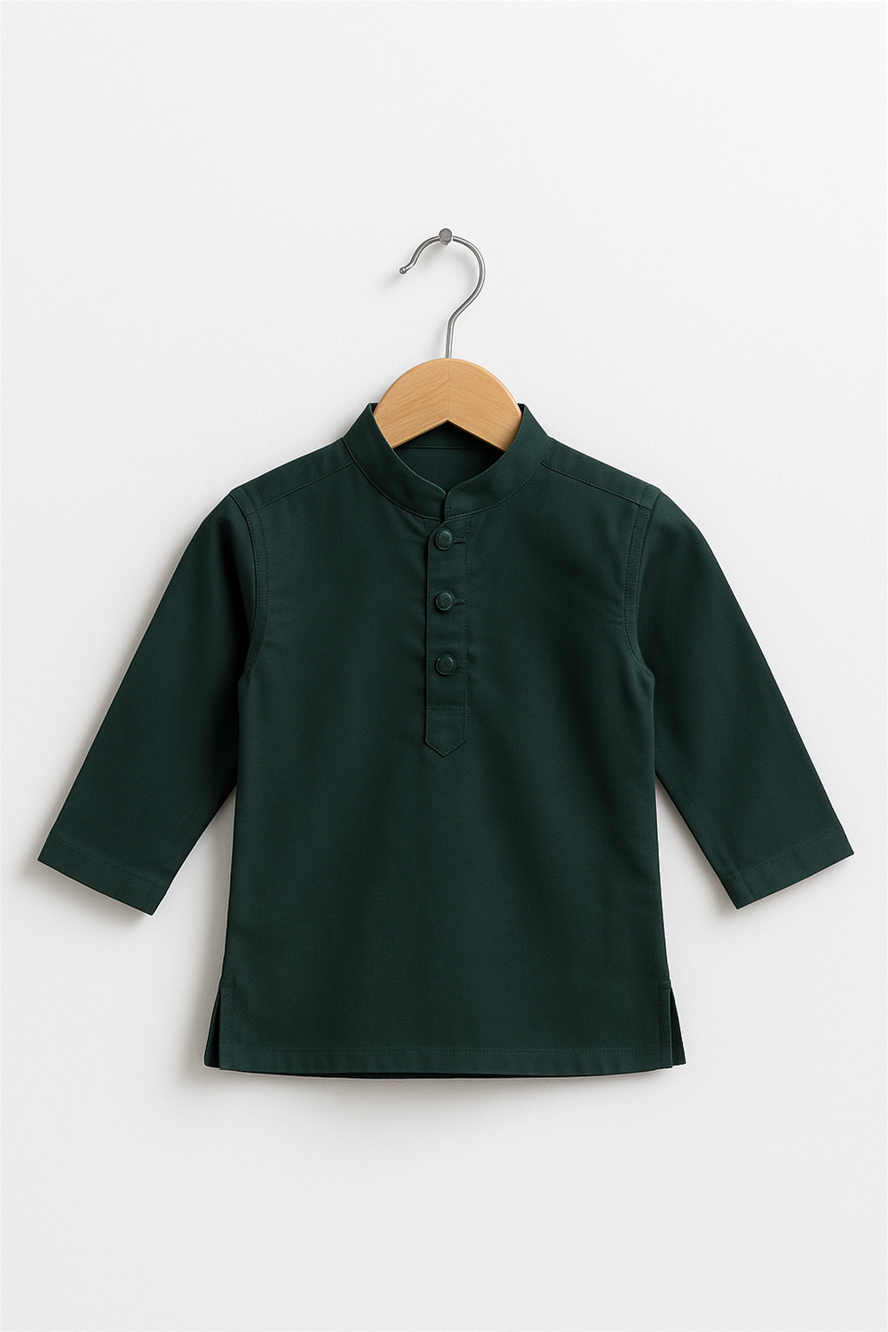 A deep green boy’s kurta with a Chinese collar and matching fabric buttons is displayed on a wooden hanger. The kurta features long sleeves and a minimal design, set against a plain white background.