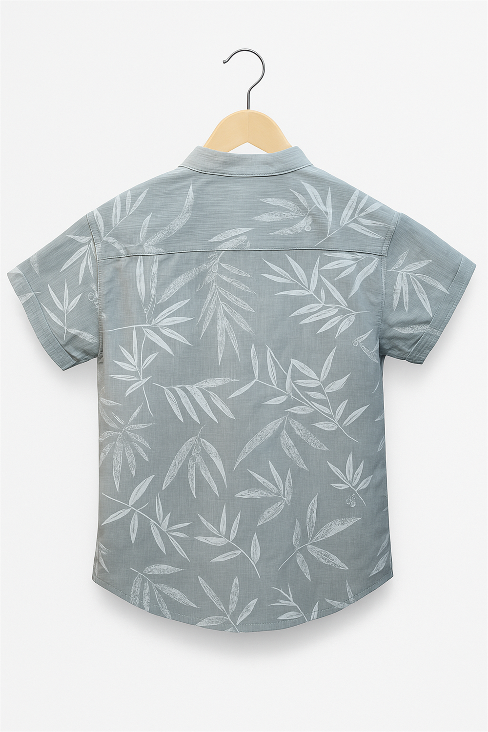 Back view of a boys’ half-sleeve shirt with a Chinese collar, displayed on a wooden hanger. The light grey shirt features a subtle all-over white leaf print, highlighting the clean stitching and yoke detail.