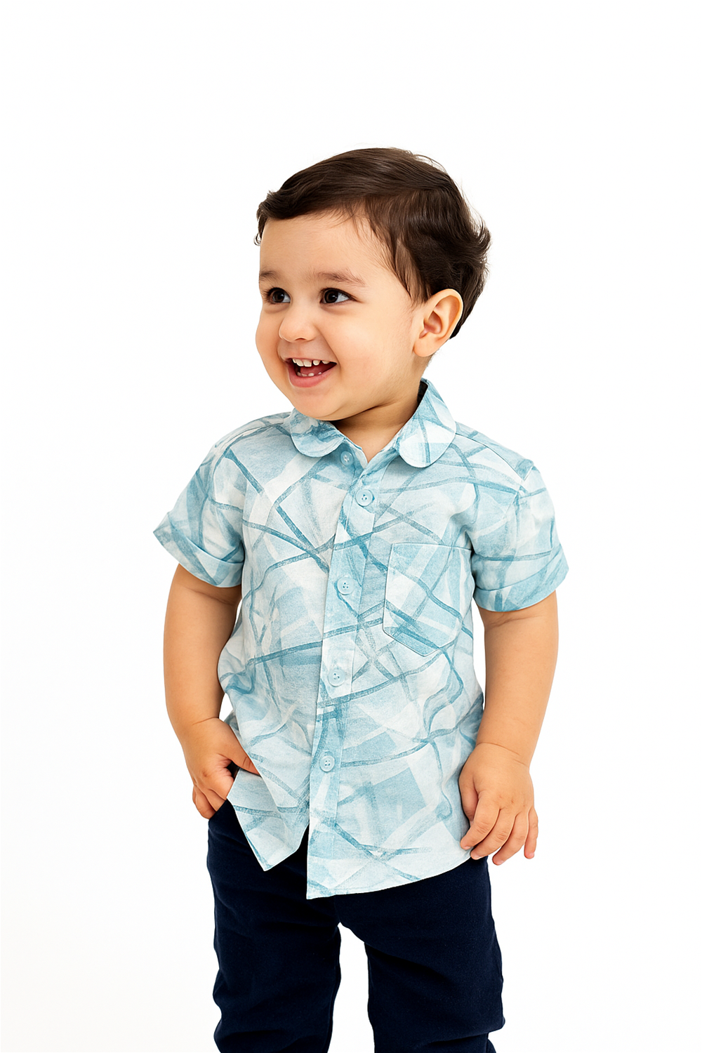 A toddler boy wearing a half-sleeve club collar shirt in a soft aqua-blue geometric pattern, styled with navy blue pants. Set against a clean white background, the shirt offers a smart and cheerful look perfect for casual or semi-formal occasions.