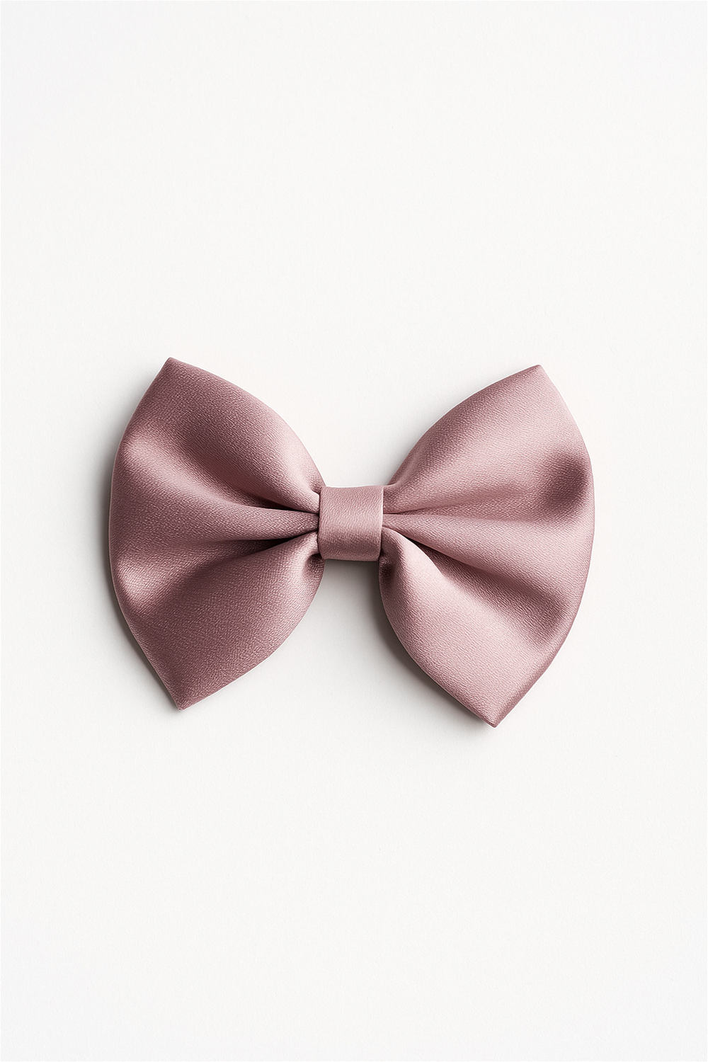 A standalone pink satin bow hair clip placed against a white background, showing its neatly folded design and gentle sheen