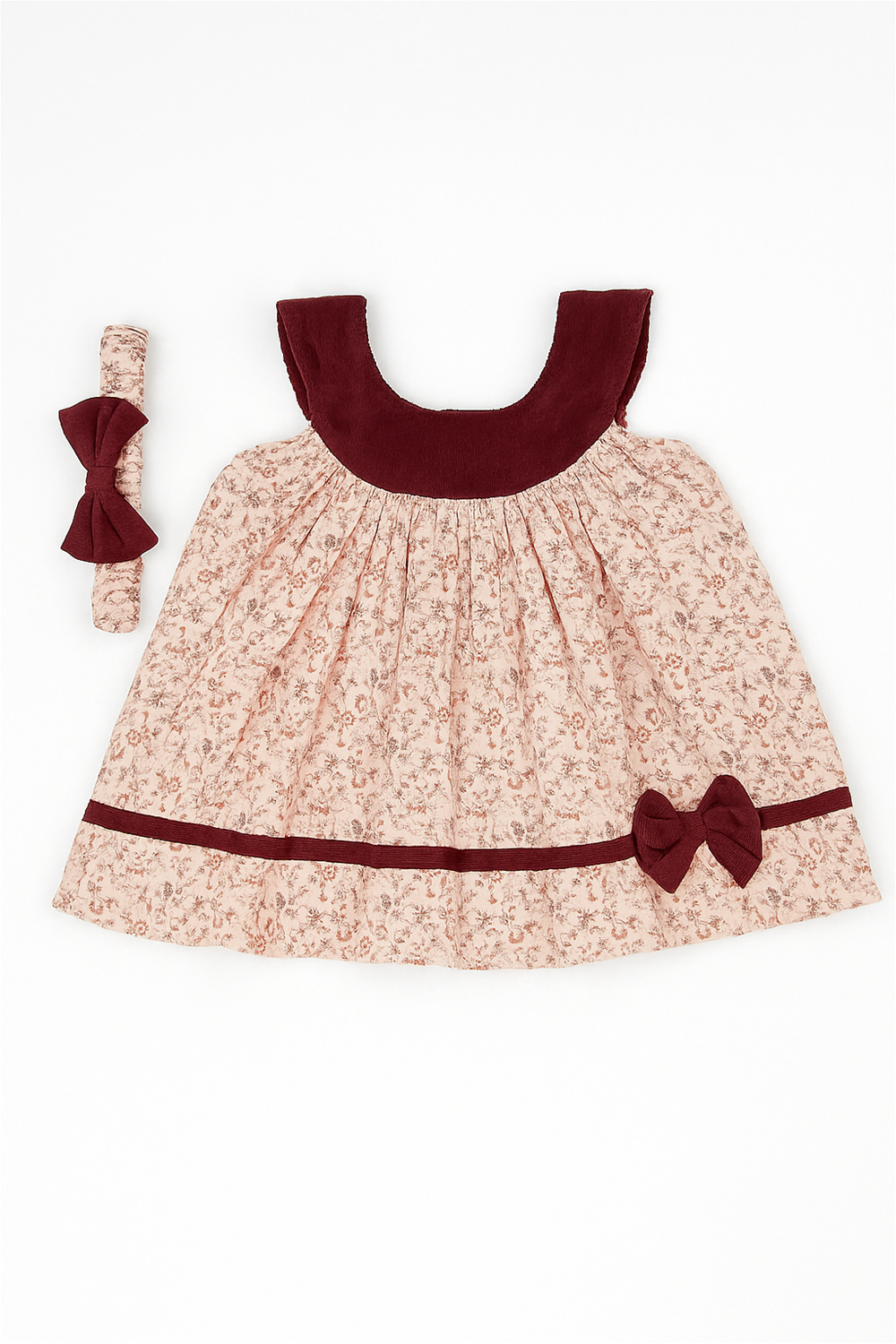 Flat lay baby dress with maroon yoke, floral print, matching bow detail, and coordinating headband on white background.