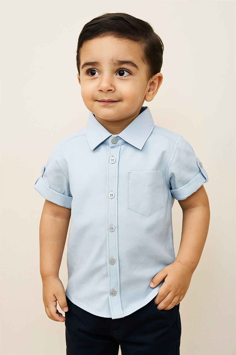 A young boy wearing a blue half-sleeve shirt with a normal collar.