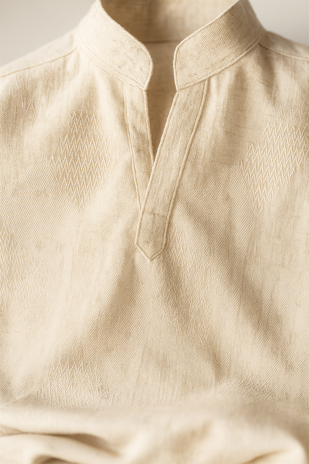 Close-up view of Off white kurta fabric, highlighting detailed woven texture, fine stitching, and elegant neckline design for product presentation.