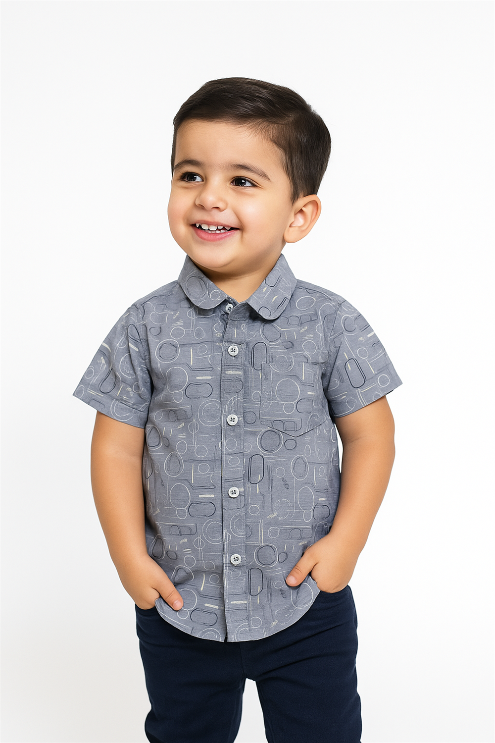 Front view of a cheerful toddler boy wearing a half-sleeve club collar shirt with playful circular patterns. The shirt features a button-down front and chest pocket, perfect for casual or semi-formal occasions.