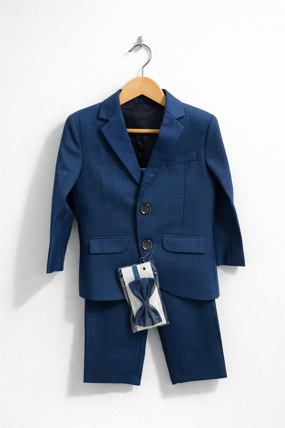 toddler boy suit displayed on wooden hanger, featuring blazer, trousers, and matching bow tie against clean white background.