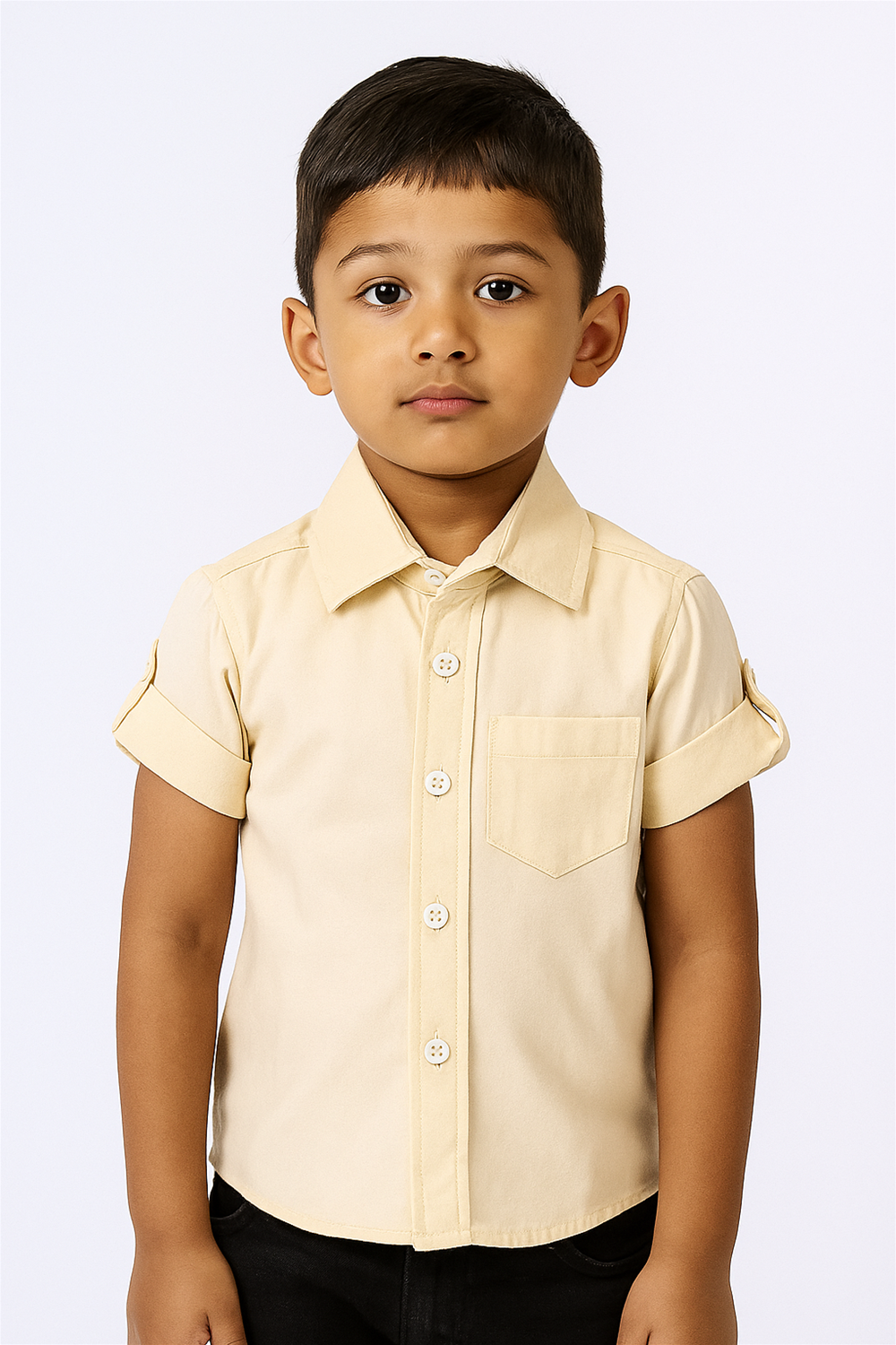 A young child stands confidently in a light yellow button-up shirt with rolled sleeves, paired with black pants against a white background.