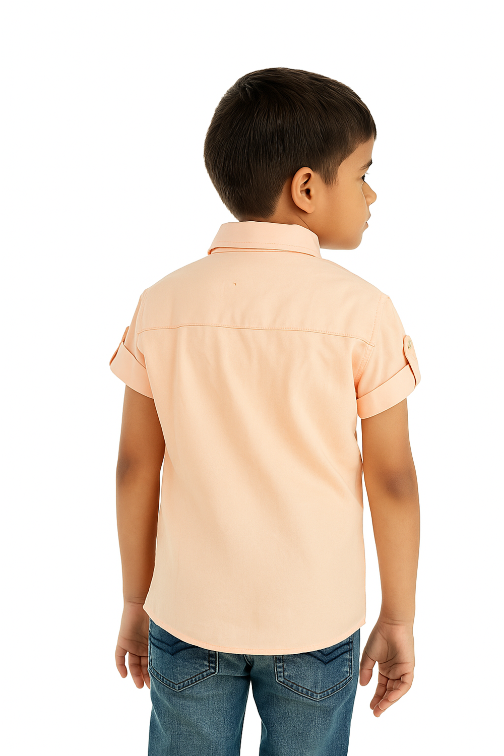A young boy in a peach half-sleeve shirt with a normal collar smiles at the camera.