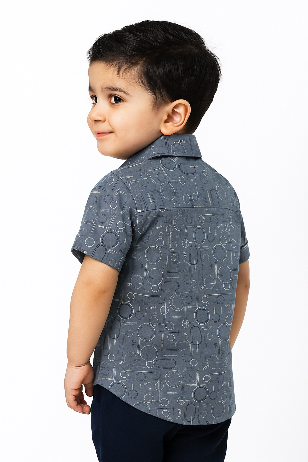 Back view of a toddler boy wearing a half-sleeve club collar shirt featuring a playful geometric circle pattern. The shirt offers a smart casual look, ideal for everyday outings or playful occasions.