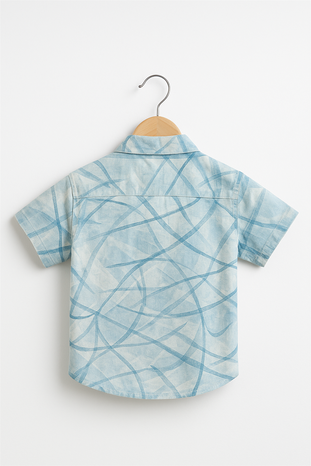 Back view of a boys' half-sleeve shirt with a soft club collar, neatly hung on a wooden hanger against a plain white background. The shirt features an abstract blue linear pattern, showcasing a clean finish and comfortable fit for casual wear.