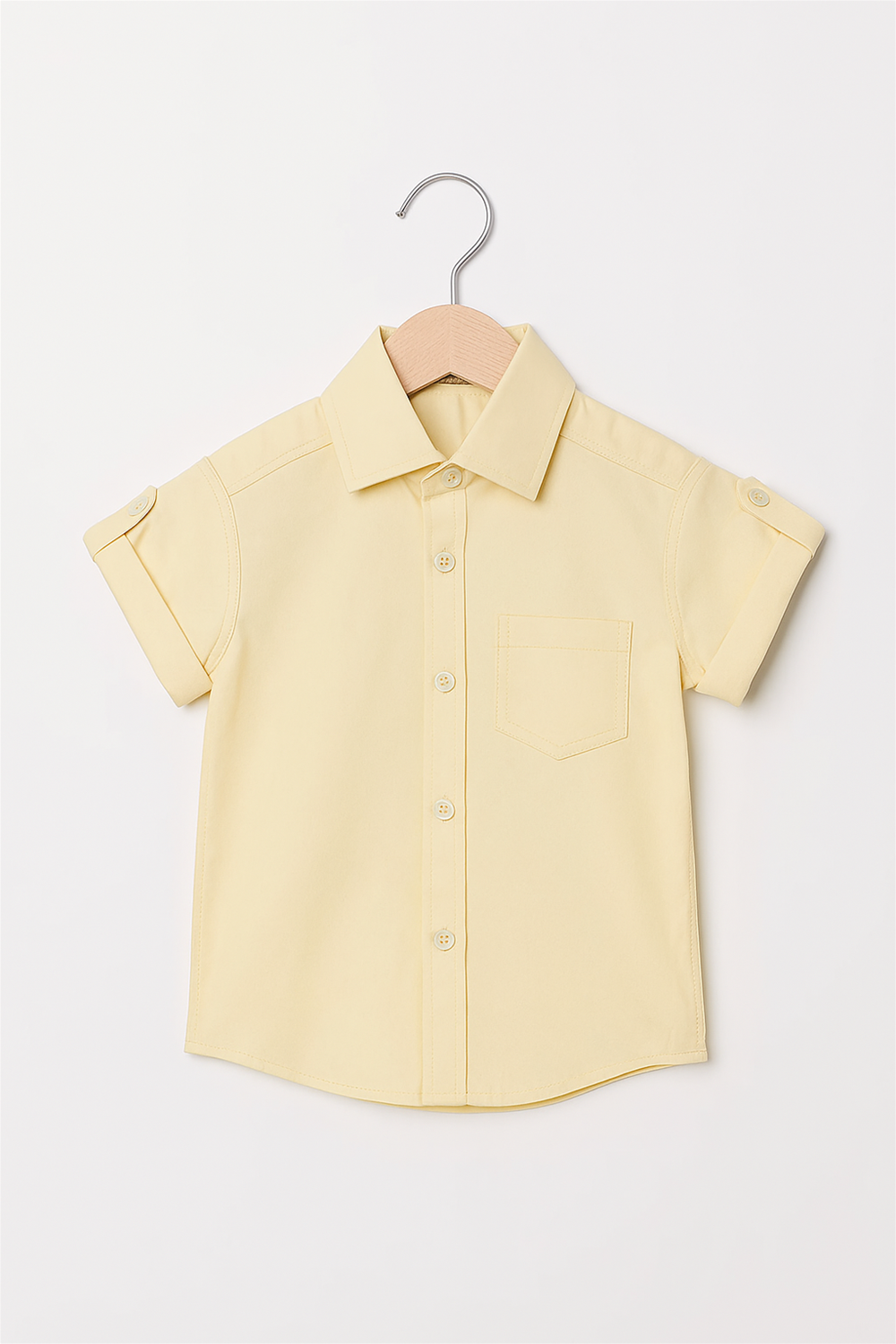 A short-sleeved yellow button-up shirt with a chest pocket, hanging on a wooden hanger against a white background.