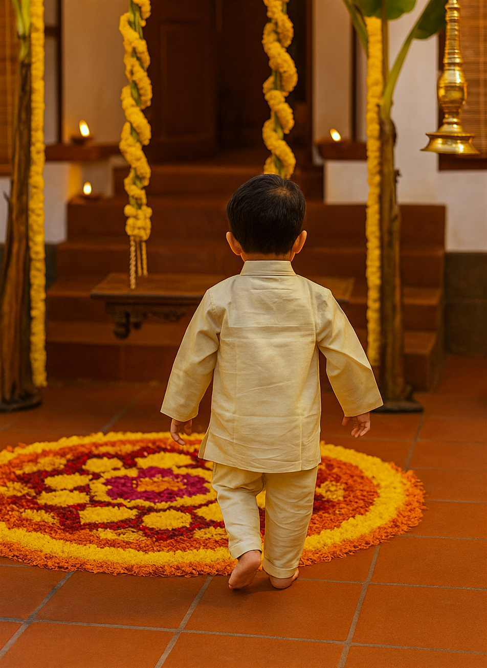 A young boy in a cream-colored traditional kurta and pajama walks barefoot towards a decorated swing. A vibrant floral rangoli and marigold garlands enhance the festive ambiance.