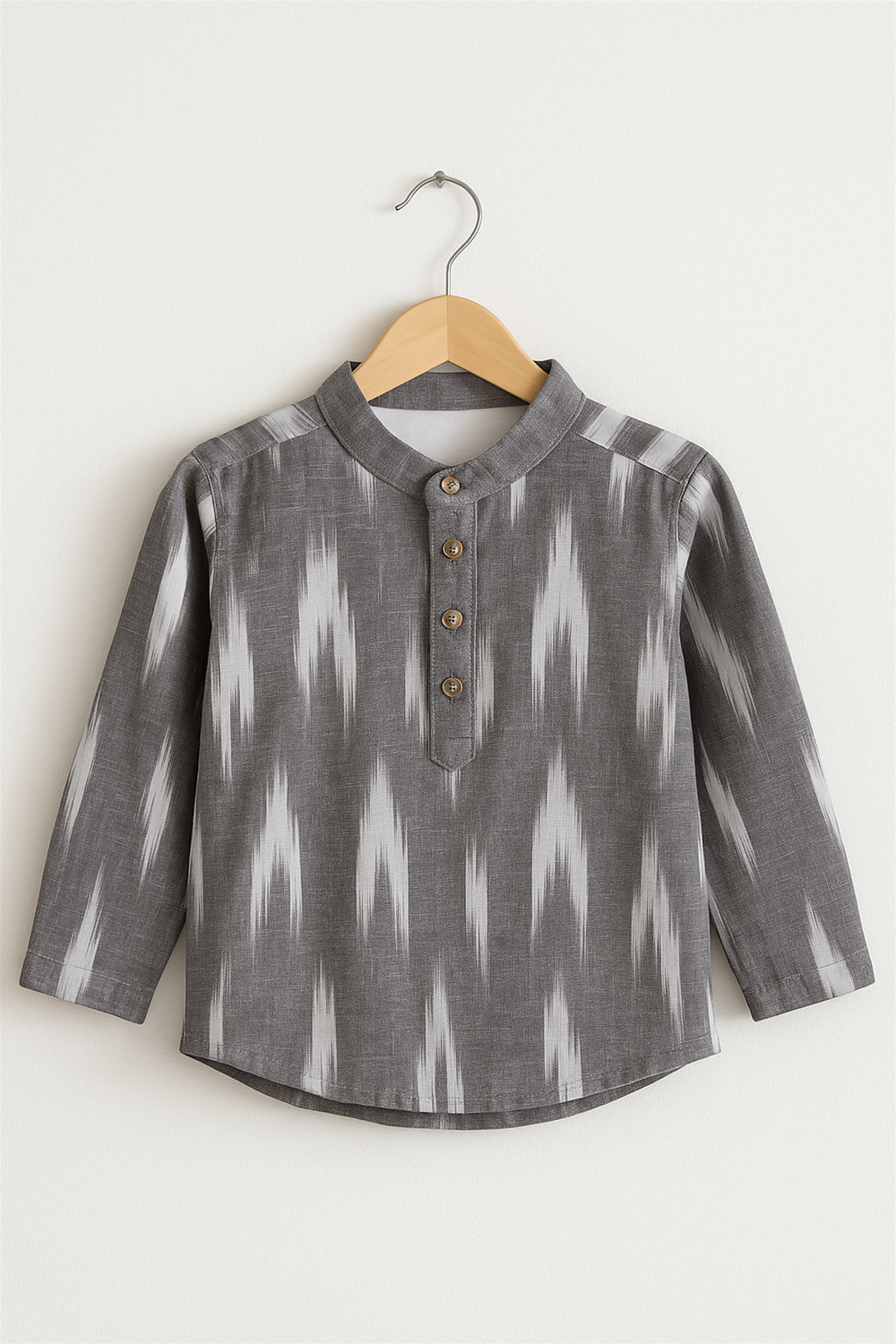 Grey ikkat cotton kurta with wooden buttons, displayed on a wooden hanger, simple background for product presentation.