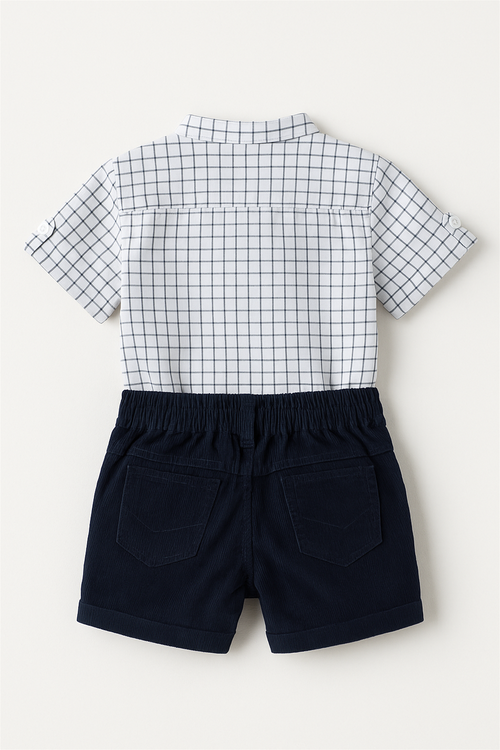 Back view of white checkered shirt with rolled sleeves and navy shorts featuring elastic waistband and stitched back pockets.