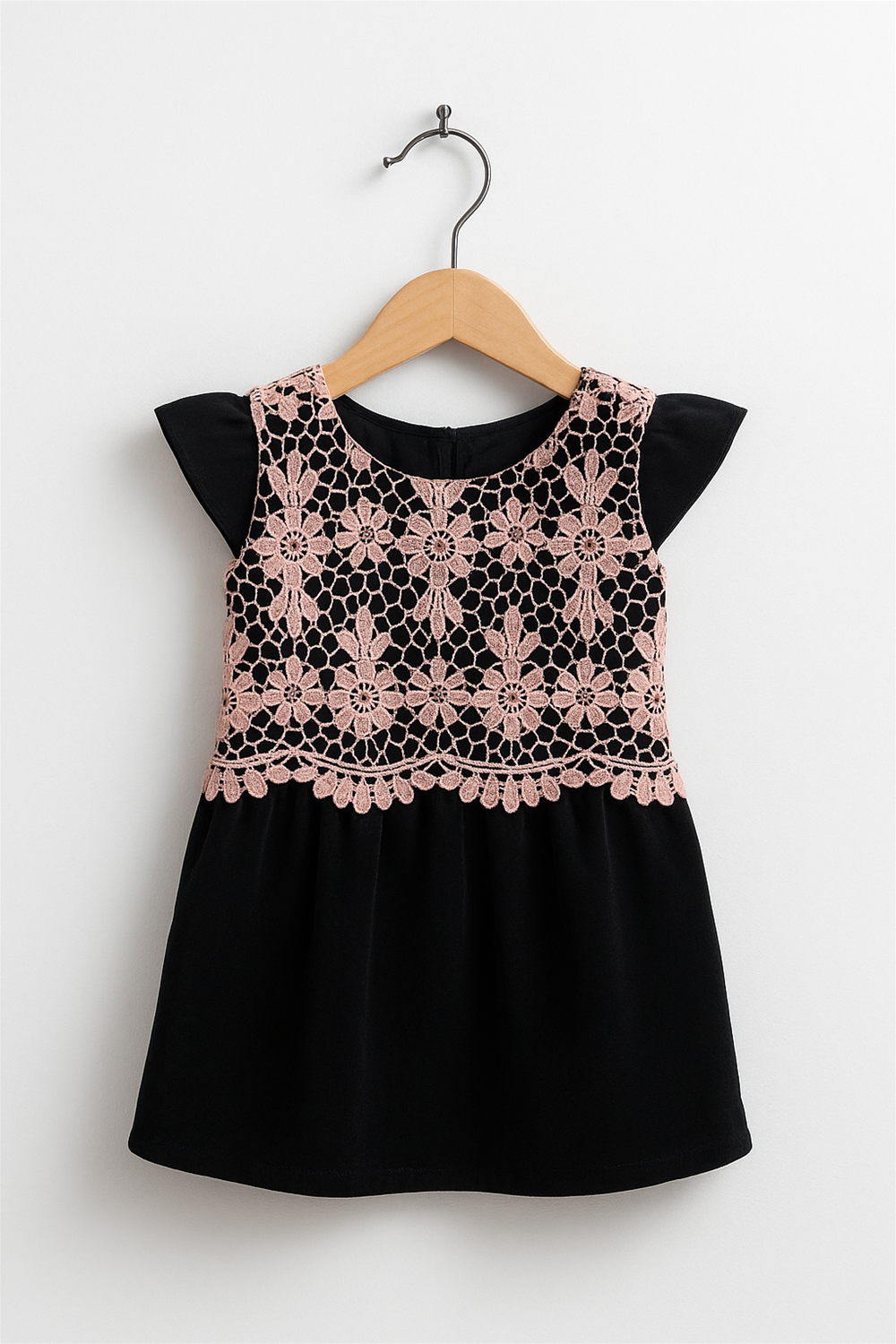  A Peach cut work with black velvet party wear frock in wooden hanger front view.