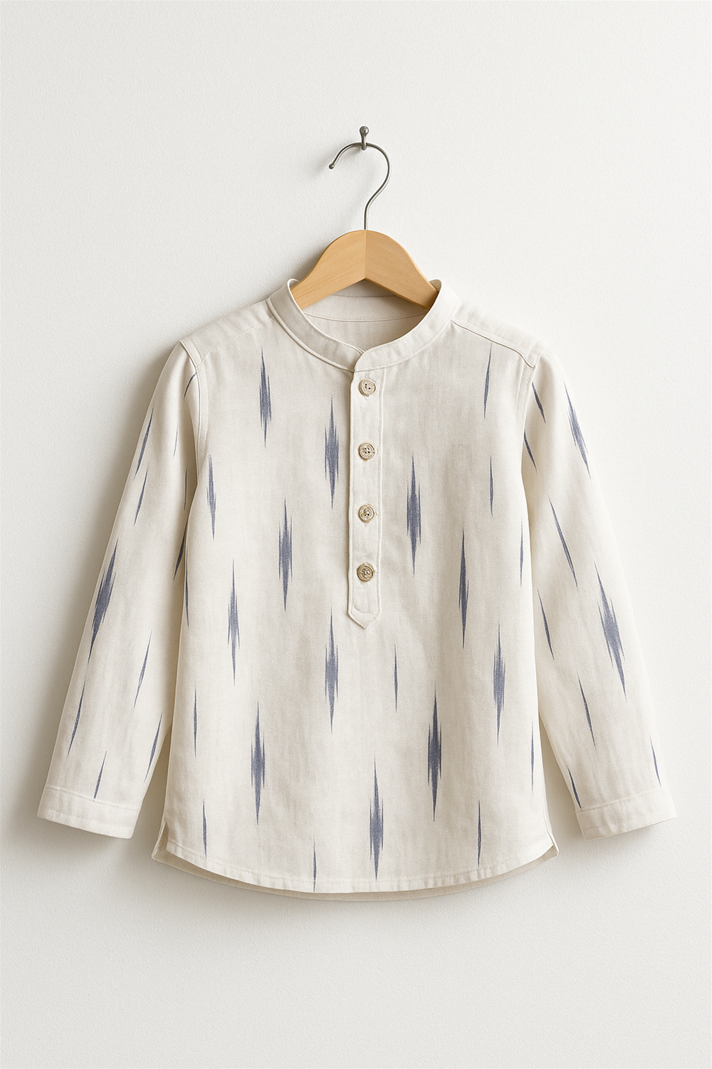 white ikkat kurta with blue patterns, long sleeves, wooden buttons, displayed neatly on a wooden hanger against white background.