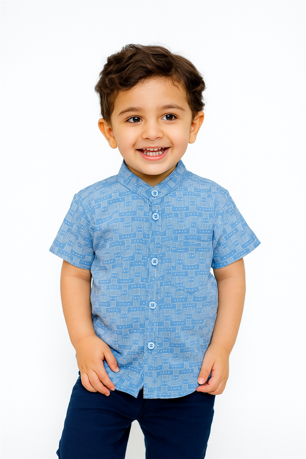 Front view of a smiling toddler boy wearing a half-sleeve Chinese collar shirt in light blue with a geometric grid pattern. The shirt features a button-down front and chest pocket, paired with dark navy blue pants in a studio setting.