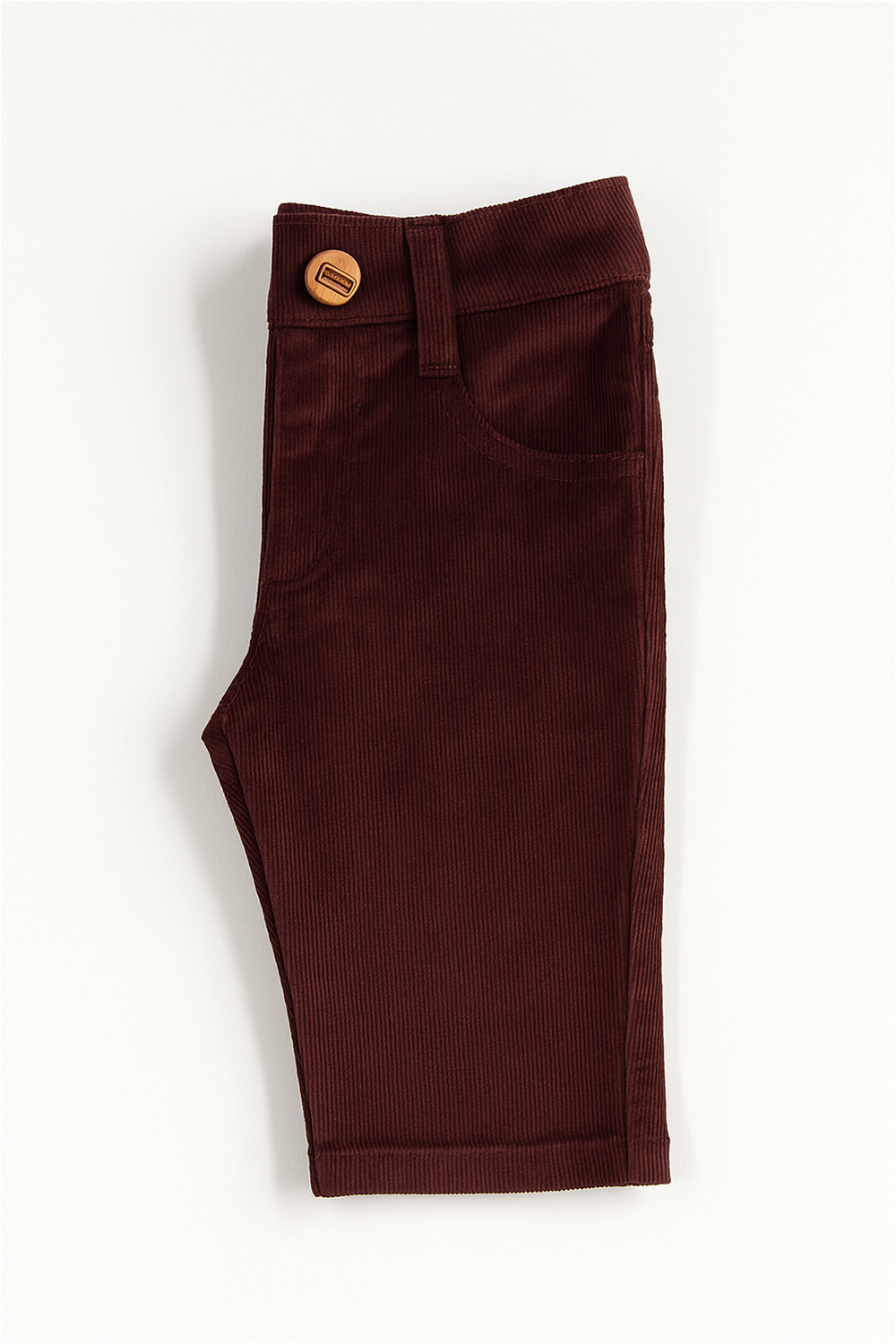 Maroon corduroy boys' full-length pants laid flat on a white background. The pants feature front scoop pockets, a coin pocket, belt loops, and a button closure at the waist. The fabric has a fine ribbed texture, giving it a soft and structured appearance.