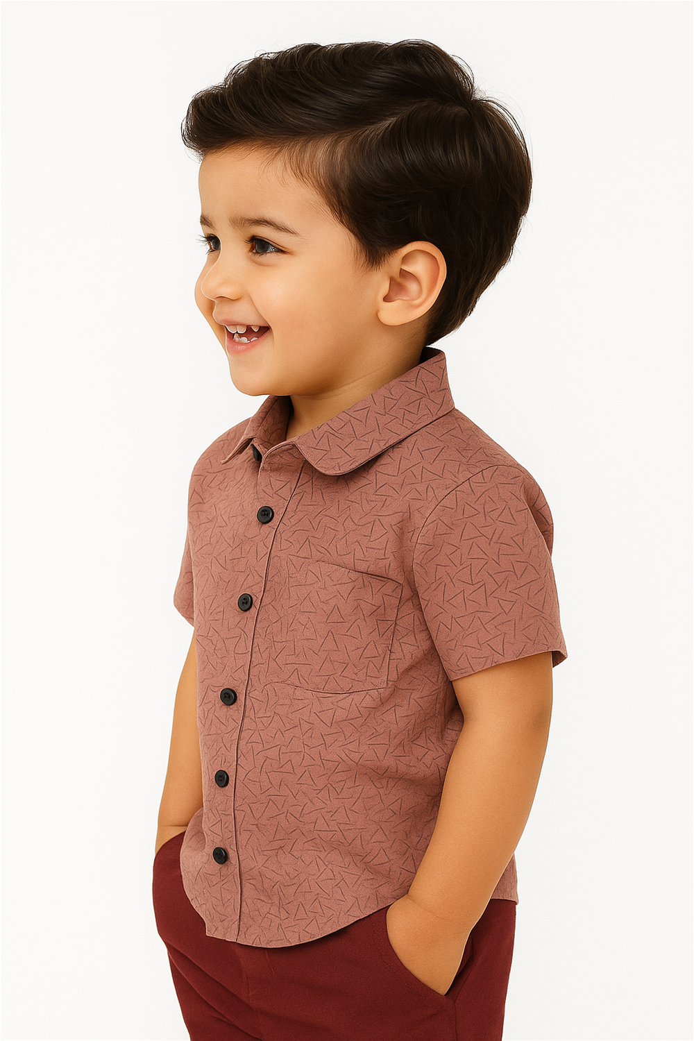 A young boy in a patterned half-sleeve shirt with a Club collar, smiling and standing against a neutral background.