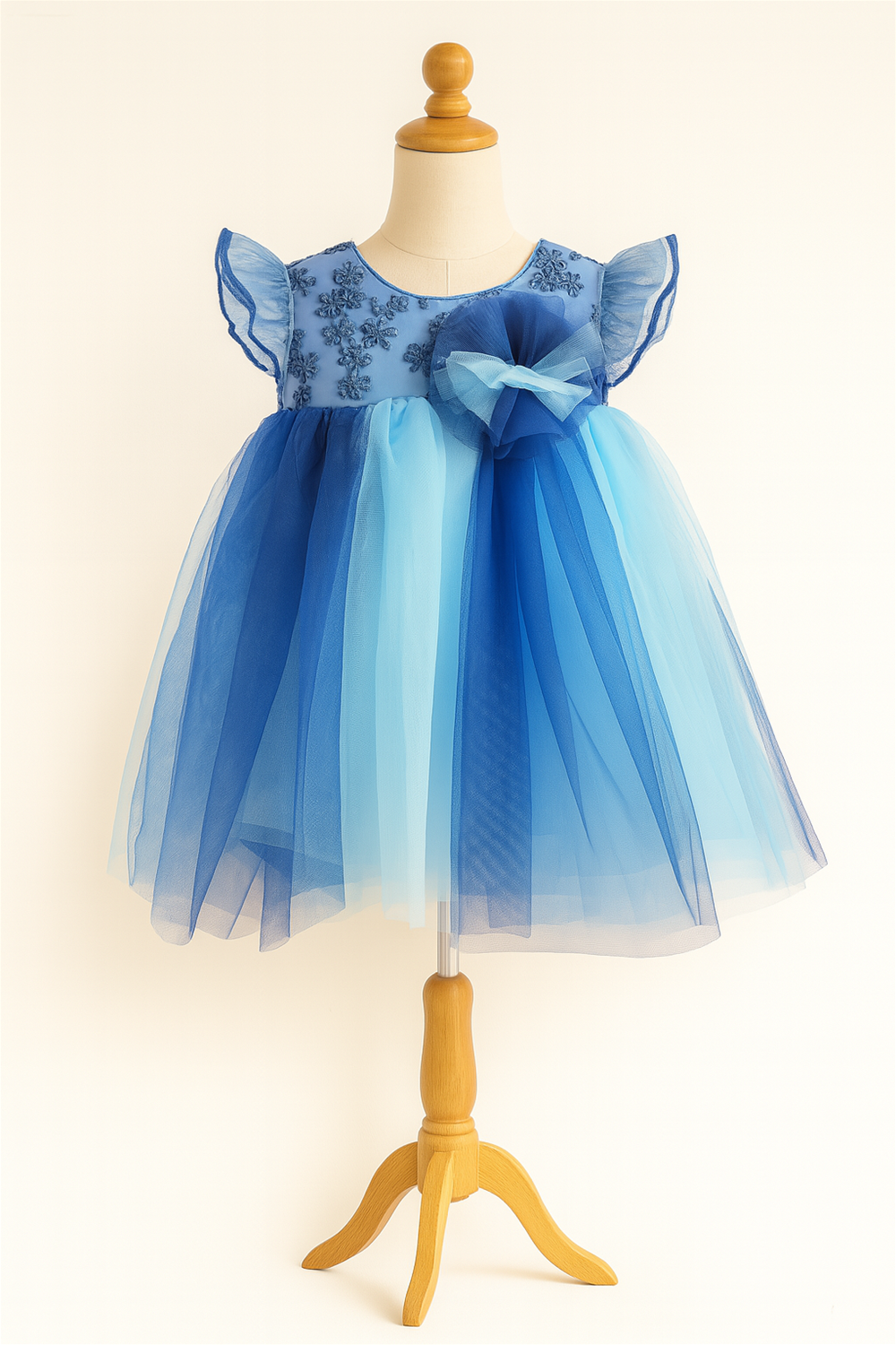 Baby girl's dress featuring a multi-color net skirt in  Light blue and Peacock blue with an alter neck design.