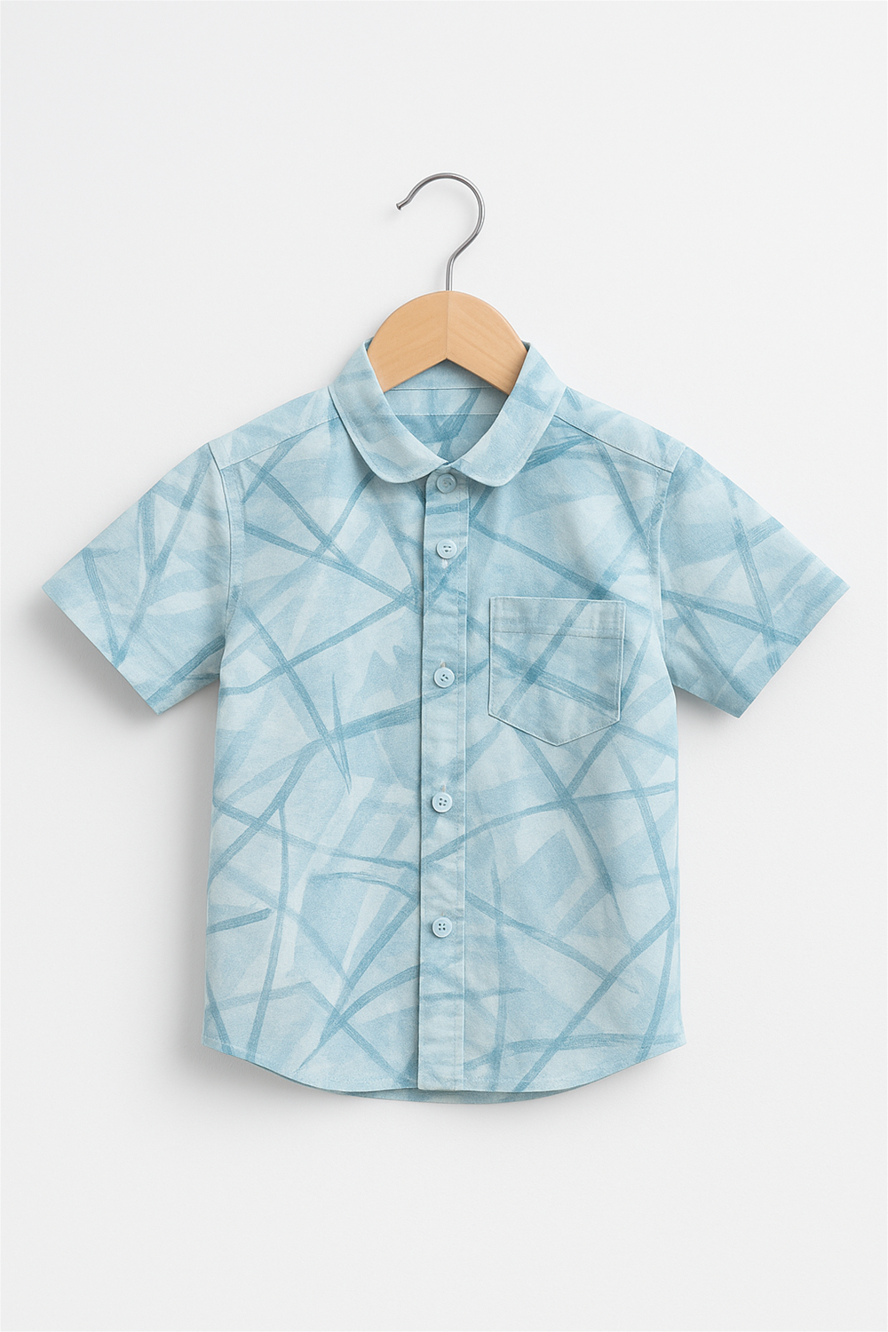 Front view of a boys' half-sleeve shirt with a soft club collar, displayed on a wooden hanger against a white background. The shirt features a light aqua abstract check pattern and a chest pocket, perfect for casual or semi-formal wear.
