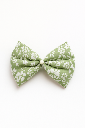 Green floral fabric bow with white flower prints and pearl center, displayed on plain white background for product presentation.
